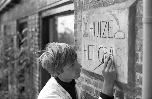 Woelrat vult de inscriptie van de gevelsteen op Huize Het Gras met zwarte rijwiellak